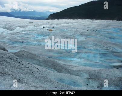 Due elicotteri, tenda e una dozzina di escursionisti sulla Mendenhall Glacier, Alaska Foto Stock