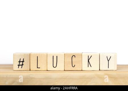 Cubi di legno con un hashtag e la parola lucky sfondo, social media concept Foto Stock