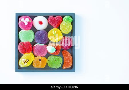 A forma di frutta gelatine in un vassoio quadrato, vista dall'alto (sfondo bianco) Foto Stock