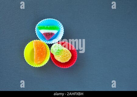 A forma di frutta gelatine vista dall'alto isolato sul vassoio di ardesia Foto Stock