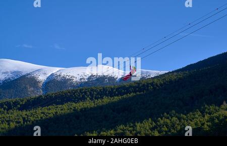 Vista posteriore del giovane uomo a cavallo su zip line contro il cielo blu Foto Stock