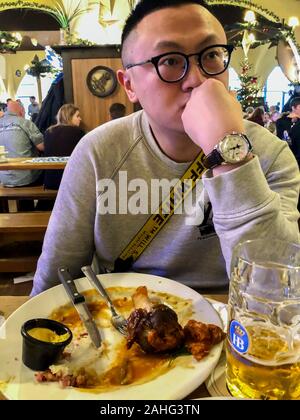 Berlino, Germania, ChineseTourists condivisione dei pasti all'interno del ristorante tedesco, l uomo a tavola, Hofbrau Wirsthaus Foto Stock