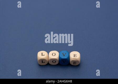 Amore messaggio parola scritta su blocchi di legno su sfondo blu, vista dall'alto. Foto Stock