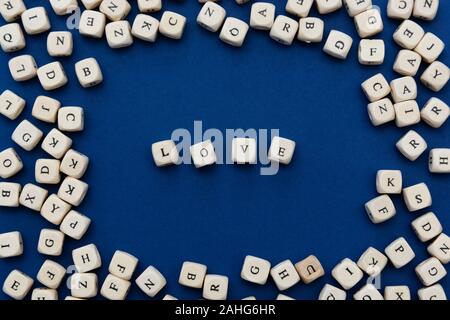 L amore è amore messaggio scritto su blocchi di legno su sfondo blu, vista dall'alto. Foto Stock
