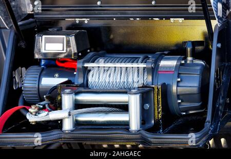 Il metallo cavo in acciaio del verricello elettrico si trova sul paraurti anteriore del vano di carico del dotato camion dei pompieri. Foto Stock