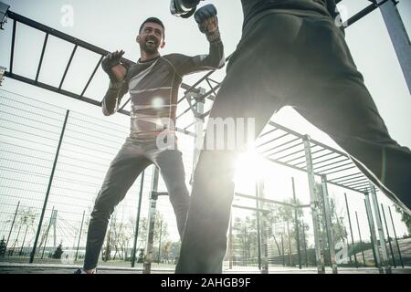 Felice boxer sorridere mentre la formazione con il suo amico Foto Stock