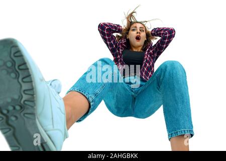 Un secondo prima di cadere. Caucasian ragazza giovane cada nel momento in cui con brillanti emozioni ed espressioni facciali. Modello femminile in abiti casual. Sconvolto, spaventata, urlando. Copyspace per annuncio. Foto Stock