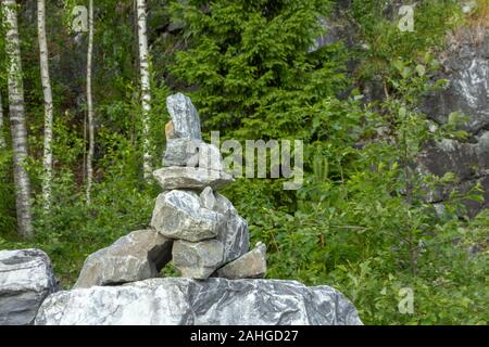 Il mucchio di pietre chiamato CAIRN nel Parco Ruskeala, Repubblica di Carelia, la Russia. Questa pila indica il modo giusto Foto Stock