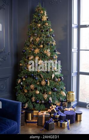 Natale classico decor. Nuovo anno. Belle le scatole blu con doni vicino la struttura ad albero Foto Stock