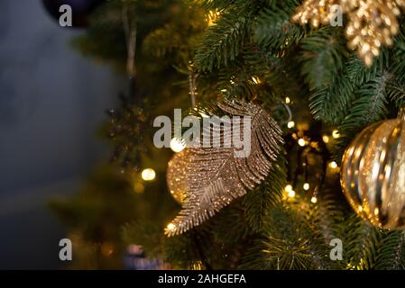 Grazioso piccolo dettaglio per la decorazione di albero di Natale. Piccola foglia oro. Holiday wallpaper Foto Stock