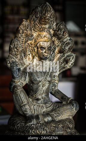 Statua grigia del Buddha con sette serpenti a testa naga per proteggere con calda luce del tramonto sul volto del Buddha Foto Stock