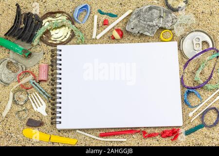 Vista superiore del vuoto del notebook su sfondo sabbia circondata da plastica reale inquinamento che si trova sulla spiaggia di plastica ridotto inquinamento zero rifiuti Nozione Foto Stock