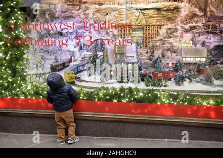 Bambino sguardi nello stupore di Macy's final store window display decorato per il Natale nel centro cittadino di Seattle. Macy's è in fase di chiusura, che termina a 73 anni di tradizione. Foto Stock