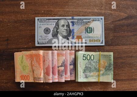 100 dollari con peso argentino bollette, simbolico per denaro tasso di cambio Foto Stock