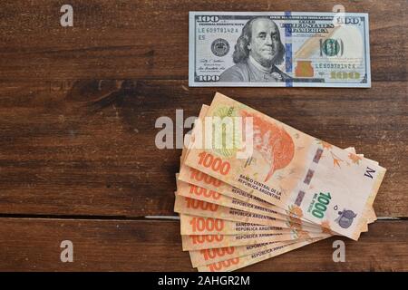 100 dollari con peso argentino bollette, simbolico per denaro tasso di cambio Foto Stock