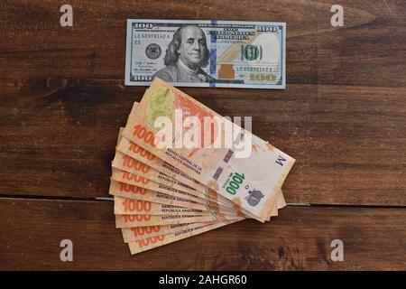 100 dollari con peso argentino bollette, simbolico per denaro tasso di cambio Foto Stock