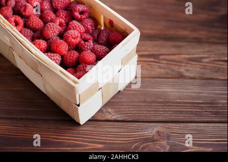 Vitamine. Estate bacche. Lamponi sfondo. Close up, vista dall'alto, alta risoluzione prodotto. Concetto di raccolto. lampone in un cestello della corteccia di betulla Foto Stock
