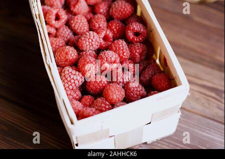 Vitamine. Estate bacche. Lamponi sfondo. Close up, vista dall'alto, alta risoluzione prodotto. Concetto di raccolto. lampone in un cestello della corteccia di betulla Foto Stock