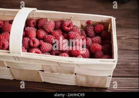 Vitamine. Estate bacche. Lamponi sfondo. Close up, vista dall'alto, alta risoluzione prodotto. Concetto di raccolto. lampone in un cestello della corteccia di betulla Foto Stock