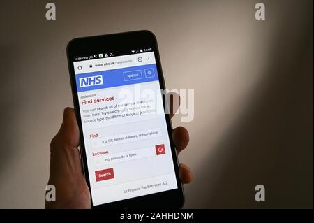 Telefono cellulare schermata di visualizzazione del sito Web di NHS. Trovare la sezione Servizi. Foto Stock