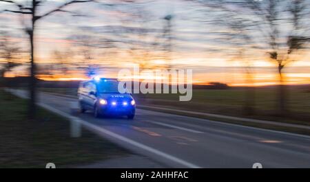 Barsinghausen, Germania. 30 Dic, 2019. Un veicolo di emergenza dall'Agenzia federale tedesca per il rilievo tecnico (THW) precipita con luce blu per un grande incendio al seminario casa Deister-Vorland Ökostation in Großgoltern nella regione di Hannover. Un fuoco era scoppiata nella ex casa colonica del mattino, che si diffuse rapidamente a tutta la travatura del tetto. Credito: Julian Stratenschulte/dpa/Alamy Live News Foto Stock