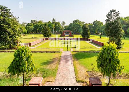 Lahore Bagh-e-Jinnah Park pittoresca vista giardino con alberi su un soleggiato Blue Sky giorno Foto Stock