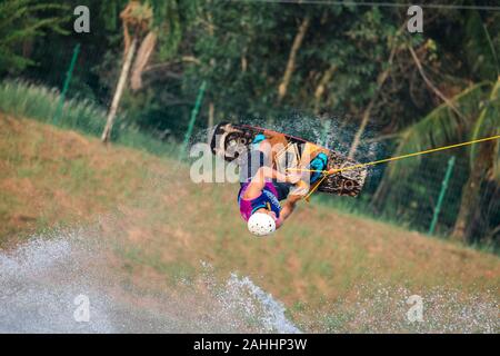 Phuket, Tailandia - 22 Aprile 2018 : guy tenere la maniglia la linea flip con wake board e flusso di acqua sparsi intorno Foto Stock