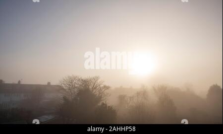 Il torneo di Wimbledon, Londra, Regno Unito. Il 30 dicembre 2019. Nebbia fitta oscura il sole la creazione di effetti atmosferici sopra giardini e tetti in South West London. Credito: Malcolm Park/Alamy Live News. Foto Stock