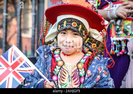 Il Covent Garden di Londra, 30 dic 2019. Un giovane attore chiamato 'Brillie' gode la sua giornata in Spotlight. Gruppo boliviano in abiti tradizionali è parte del Carnevale del Pueblo, portando colorata cultura latino-americana per i festeggiamenti.Il London Capodanno Parade (o LNYDP) hanno scelto la vibrante Covent Garden Piazza per questo anno di evento di anteprima, presentazione di molti dei loro gruppi di partecipanti. La parata di per sé avrà inizio alle ore 12 del 1 gennaio e passare attraverso il centro di Londra. Credito: Imageplotter/Alamy Live News Foto Stock