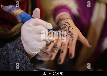 La città di Gaza, la striscia di Gaza, la Palestina. 30 Dic, 2019. Una ragazza palestinese che dà il benvenuto al nuovo anno dal disegno di una Henna Tattoo con il nuovo anno 2020 numeri sulla sua mano a Gaza city Credit: Majd Abed/Quds Net News/ZUMA filo/Alamy Live News Foto Stock