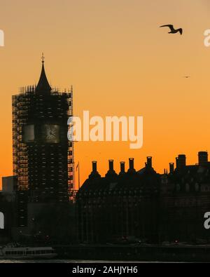 Westminster, Londra, 30 dic 2019. Le Case del Parlamento stagliano al tramonto, con la torre di Elizabeth ancora in un ponteggio. Un splendidamente soleggiata giornata invernale a Londra si conclude con un delicato pastello tramonto a Westminster. Credito: Imageplotter/Alamy Live News Foto Stock