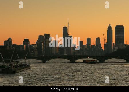 Westminster, Londra, 30 dic 2019. Molti nuovi blocchi di appartamenti ed edifici in Vauxhall e Nine Elms al tramonto dal Tamigi. Un splendidamente soleggiata giornata invernale a Londra si conclude con un delicato pastello tramonto a Westminster. Credito: Imageplotter/Alamy Live News Foto Stock