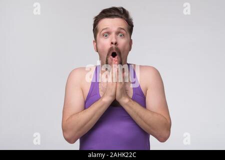 Giovane uomo fitness indossa casual sports felpa sconvolto con espressione sorpresa Foto Stock