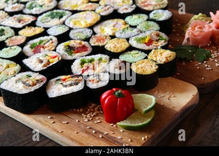 Sushi set - diversi tipi di Maki Sushi e nigiri sushi. Servita su legno scuro tavolo. Foto Stock