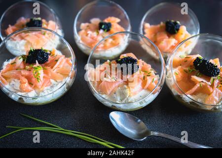 Salmone verrine ciclottero uovo formaggio fresco e letto di avocado in cucina Foto Stock