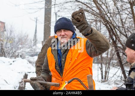 Lavoratori nei servizi municipali sono la riparazione di un tubo rotto. Foto Stock