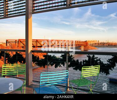 Il ponte e lo stagno di Scissortail Park nel centro di Oklahoma City sono visti dal patio della Boathouse in una serata invernale. Foto Stock