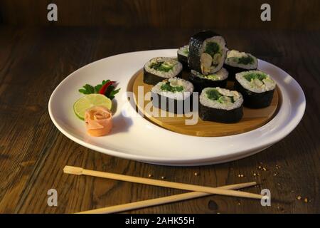 Sushi set - diversi tipi di Maki Sushi e nigiri sushi. Servita su legno scuro tavolo. Foto Stock