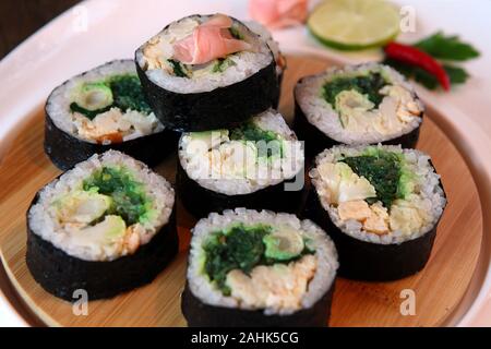 Sushi set - diversi tipi di Maki Sushi e nigiri sushi. Servita su legno scuro tavolo. Foto Stock