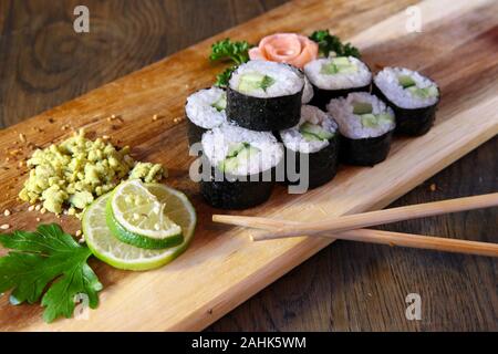 Sushi set - diversi tipi di Maki Sushi e nigiri sushi. Servita su legno scuro tavolo. Foto Stock