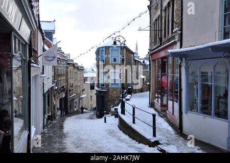 Ripide e scivolose Catherine Hill nella neve. Poche persone sono a camminare su questa strada di ciottoli a Frome ,Somerset. Foto Stock