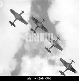 Basso angolo vista di quattro P-51 Mustangs aerei da combattimento volare in formazione, Ramitelli, Italia, fotografia di Toni Frissell, Marzo 1945 Foto Stock