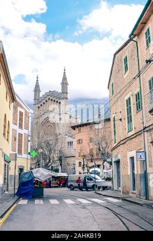 Soller, Mallorca, Spagna - Jan 19, 2019: Old town street nel centro storico della città spagnola con la chiesa di Sant Bartomeu in background. Popolare attrazione turistica. Foto verticale. Foto Stock