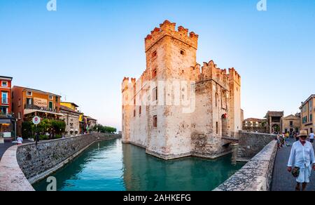 Sirmione, Lombardia, Italia - 12 Settembre 2019: Panorama del castello Scaligero o il castello di Sirmione circondata da canali di acqua del lago di Garda. Peopl Foto Stock