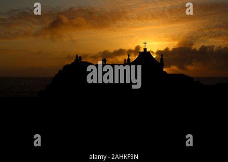 Cappella con la silhouette della gente al tramonto. Contre-jour. Leça Da Palmeira, Porto, Portogallo. Foto Stock