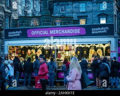 Persone che acquistano merce per Hogmanay di Edimburgo a street bancarella vendendo merci ufficiale, Royal Mile di Edimburgo, Scozia, Regno Unito Foto Stock