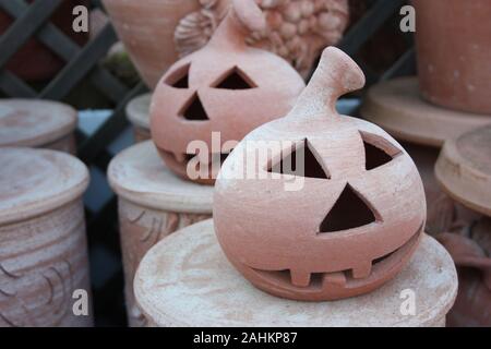 Artigianale di vasi di terracotta per la festa di Halloween a forma di zucca con una brutta faccia spaventando Foto Stock