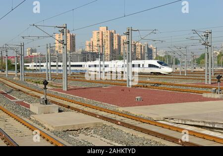 Una elevata velocità del treno bullet si allontana da Pechino a sud della stazione ferroviaria di Pechino, Cina, su una chiara mattina di aprile Foto Stock