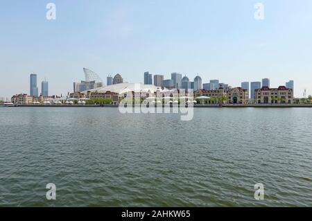 Vista sul fiume Haihe verso il lungofiume della zona di libero scambio di Binhai, Tianjin, Cina, con l'edificio Haicheng Polar World in primo piano Foto Stock