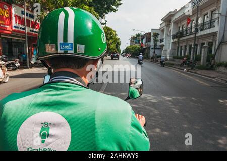 La vista dal retro di un Grab Bike come il ciclista passa il traffico in Hanoi, Vietnam. Grab è il Sud Est Asiatico più popolare ride-salutando app Foto Stock